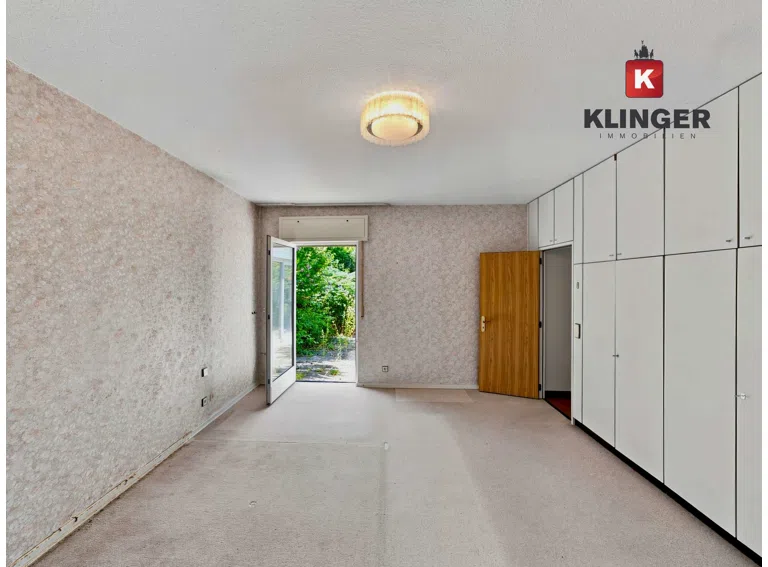 Schlafzimmer mit Einbauschränken und Zugang zum Außenbereich