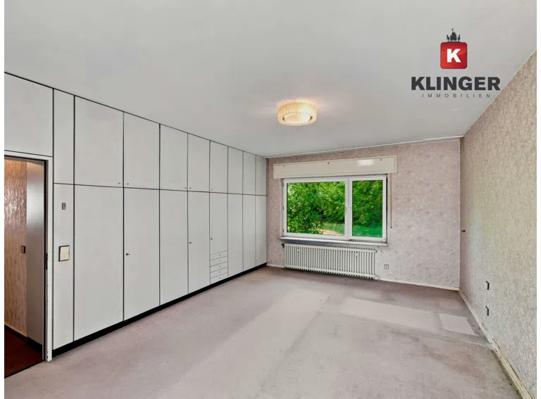 Schlafzimmer mit Einbauschränken und Zugang zum Außenbereich
