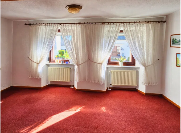 Aufgeräumtes Zimmer mit rotem Teppich