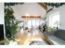 lichtdurchflutetes Wohnzimmer mit hoher Decke und Zugang zum Balkon
