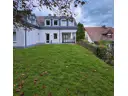 7 Blick vom der Wohnung zugeordneten Gartenanteil auf die Terrasse und Wohnung