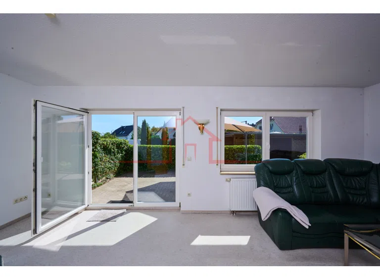 Blick in das helle und großzügige Wohnzimmer mit Zugang zur sonnigen Terrasse