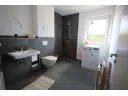 Modernes Badezimmer mit bodengleicher Dusche und zeitgemäßer Ausstattung