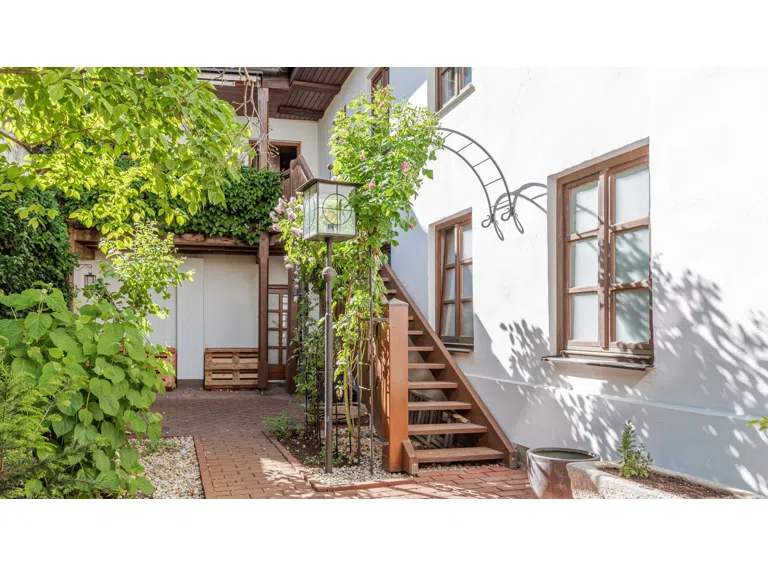 Garten mit Treppe hinauf zu Balkon und Wohnung