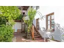Garten mit Treppe hinauf zu Balkon und Wohnung