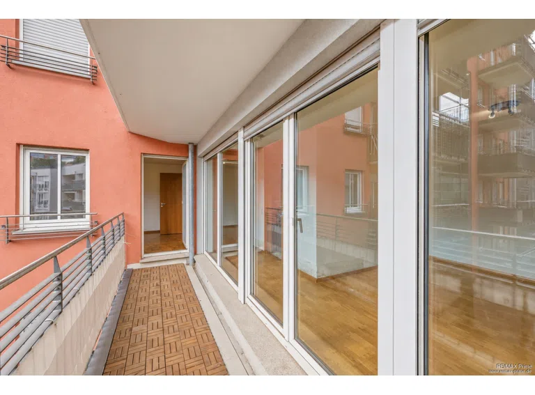 Überdachter Balkon mit großzügigen Fensterflächen