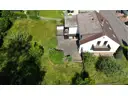 Seitenansicht mit Terrasse, Balkonen und Garten